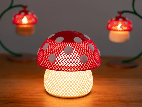 A warm, glowing 3D-printed mushroom-shaped LED desk lamp with a spotted cap