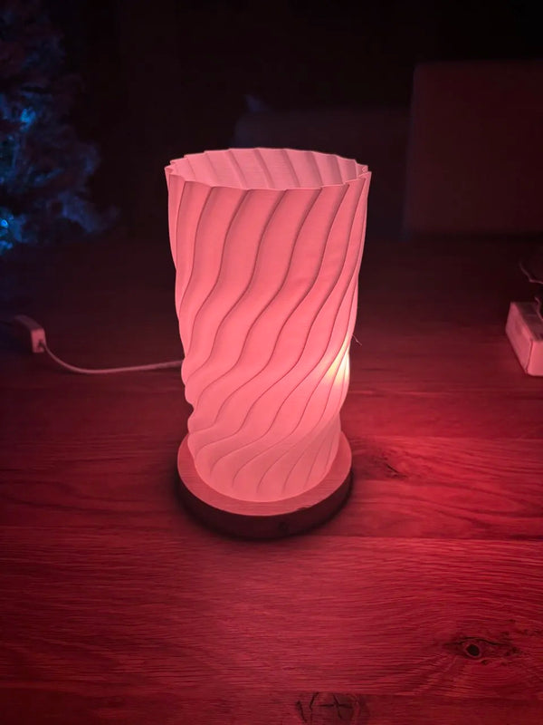 Minimalist 3D-printed lamp shade glowing softly on a desk, printed in vase mode from light PLA
