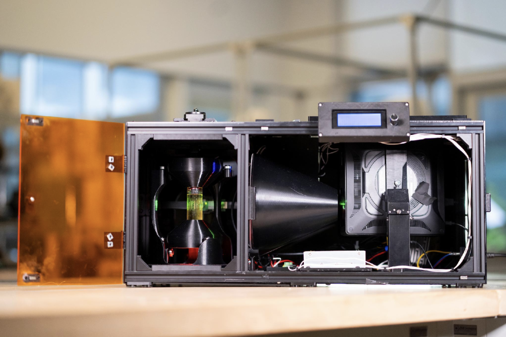Researchers' OpenCAL volumetric 3D printer, a build-it-yourself machine that cures a whole part inside a rotating vial of resin