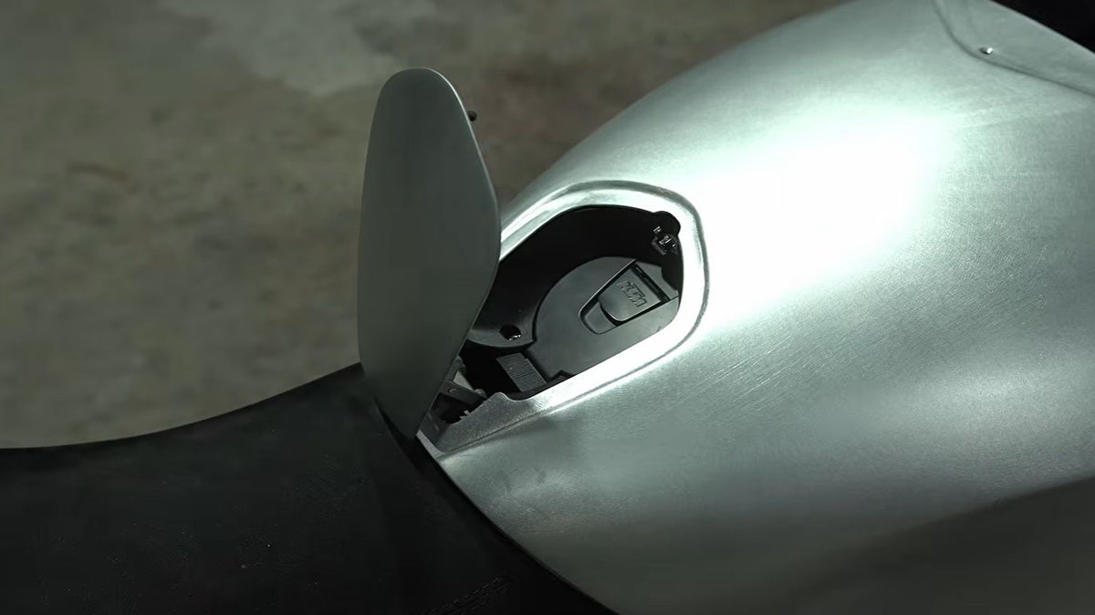 Custom 3D-printed hinge holding open a hidden fuel access panel on a modified motorbike