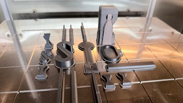 Side-by-side PC-ABS 3D printed test parts comparing desktop FDM prints with industrial FDM prints