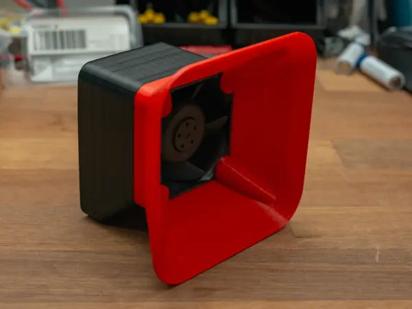 A small 3D printed tabletop fume extractor built from a repurposed server cooling fan and a cut-to-size filter, sitting on a workbench