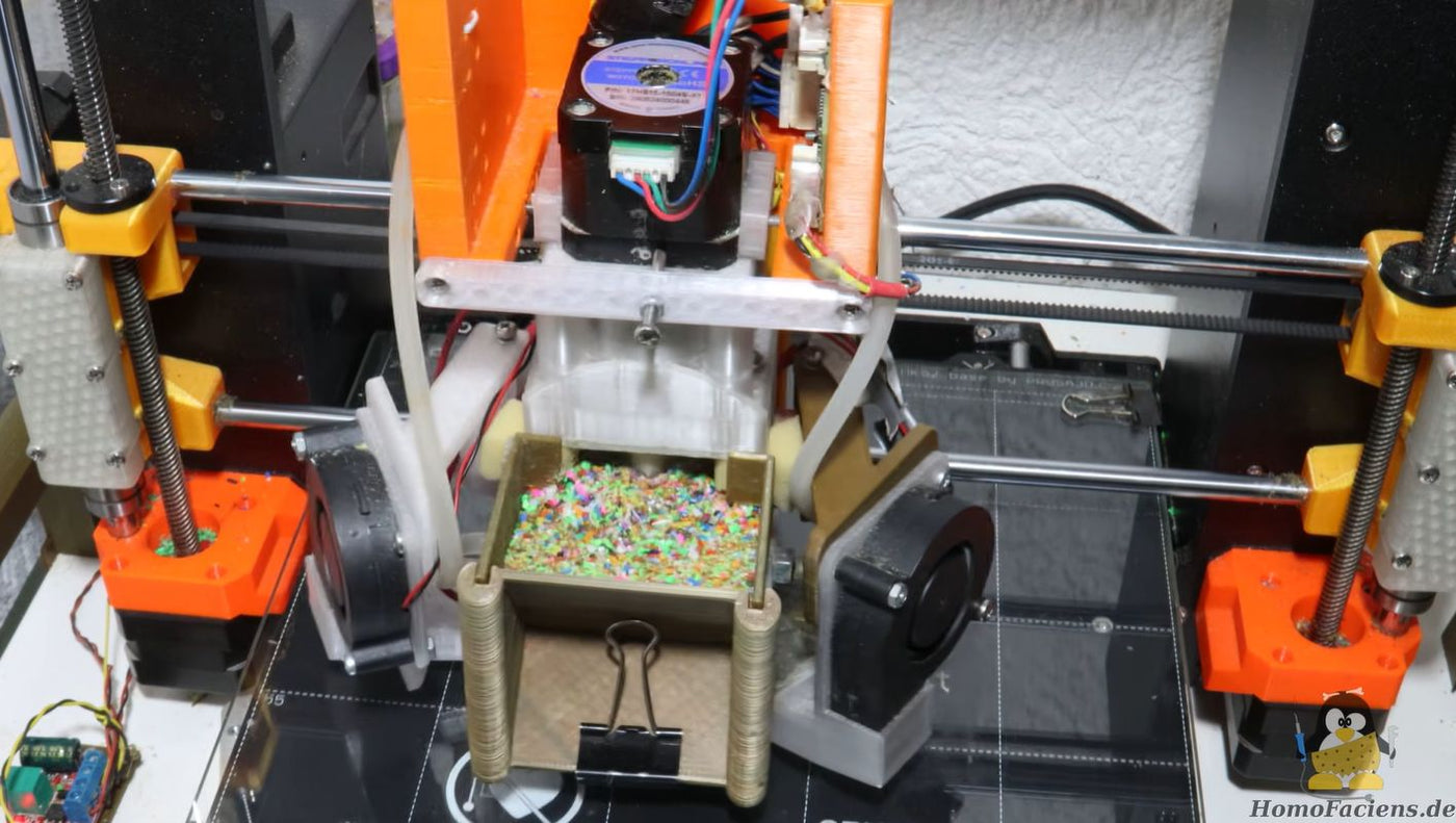 Experimental direct granules extruder mounted on a Prusa MK4 3D printer, with a hopper of plastic pellets feeding a water-cooled auger barrel.